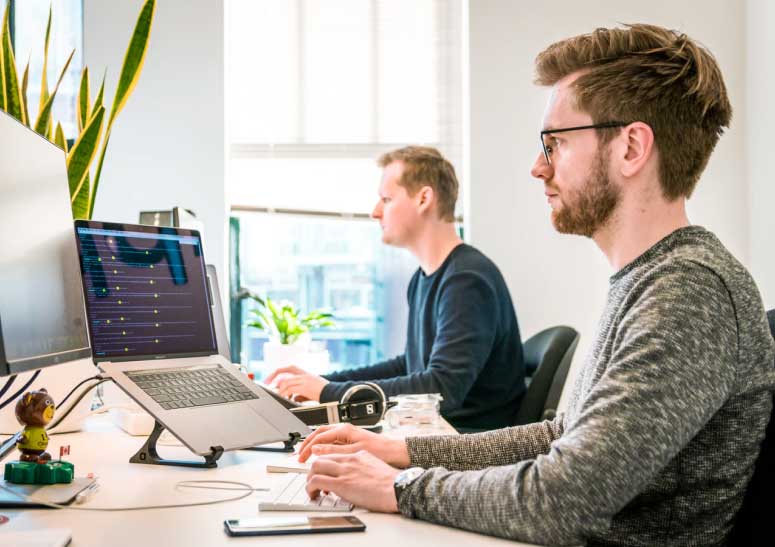 image of men working on laptop